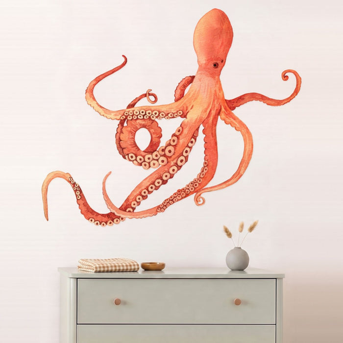 Large octopus wall decal above a sage dresser in a nursery