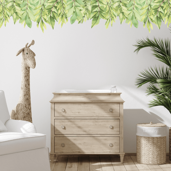 Green leaf wall trim decal along the top of a wall above a timber dresser