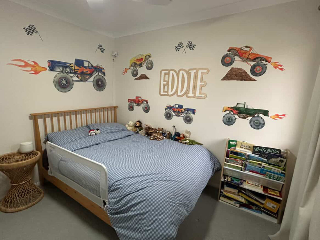A hand smoothing a fabric wall decal onto a painted wall