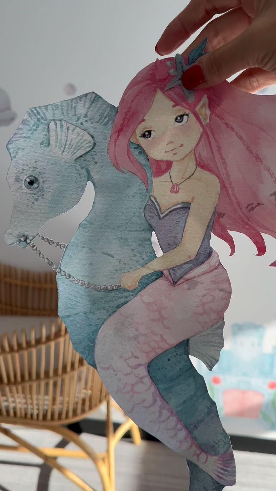 Hand holding a watercolour mermaid wall decal