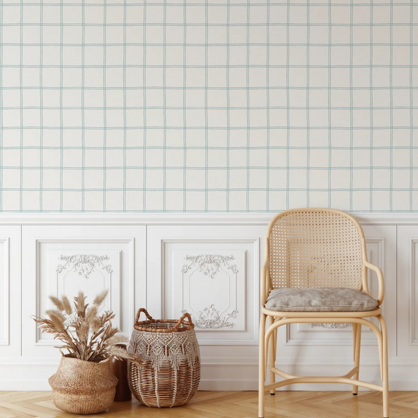 Wicker chair with a cushion next to a woven basket against a tiled wall.