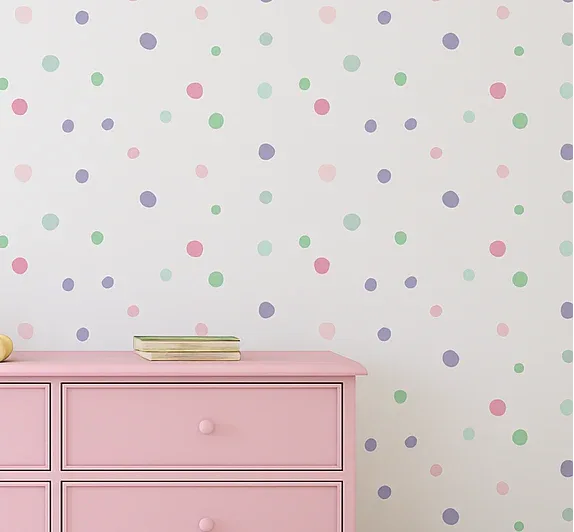 Pink dresser with toys against a polka dot wall