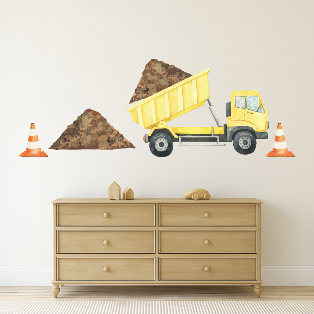 Yellow dump truck wall decal on a beige wall above a wooden dresser.