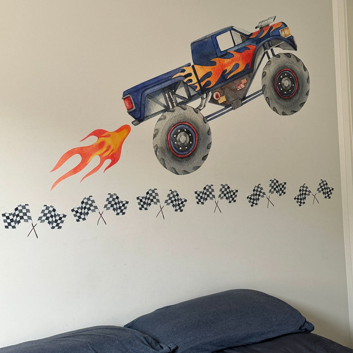 Blue monster truck decal with flames above a checkered flag border