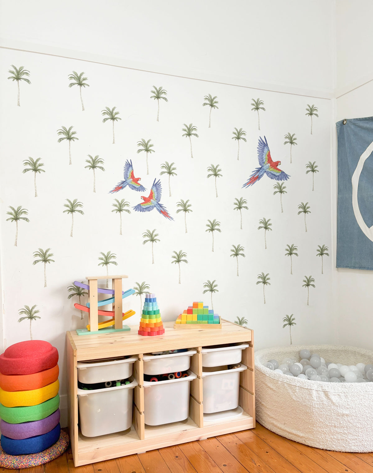 Mini palm tree and parrot decals in a playroom with toy storage