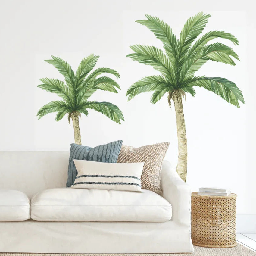 Living room with palm tree wall decals and a white sofa.