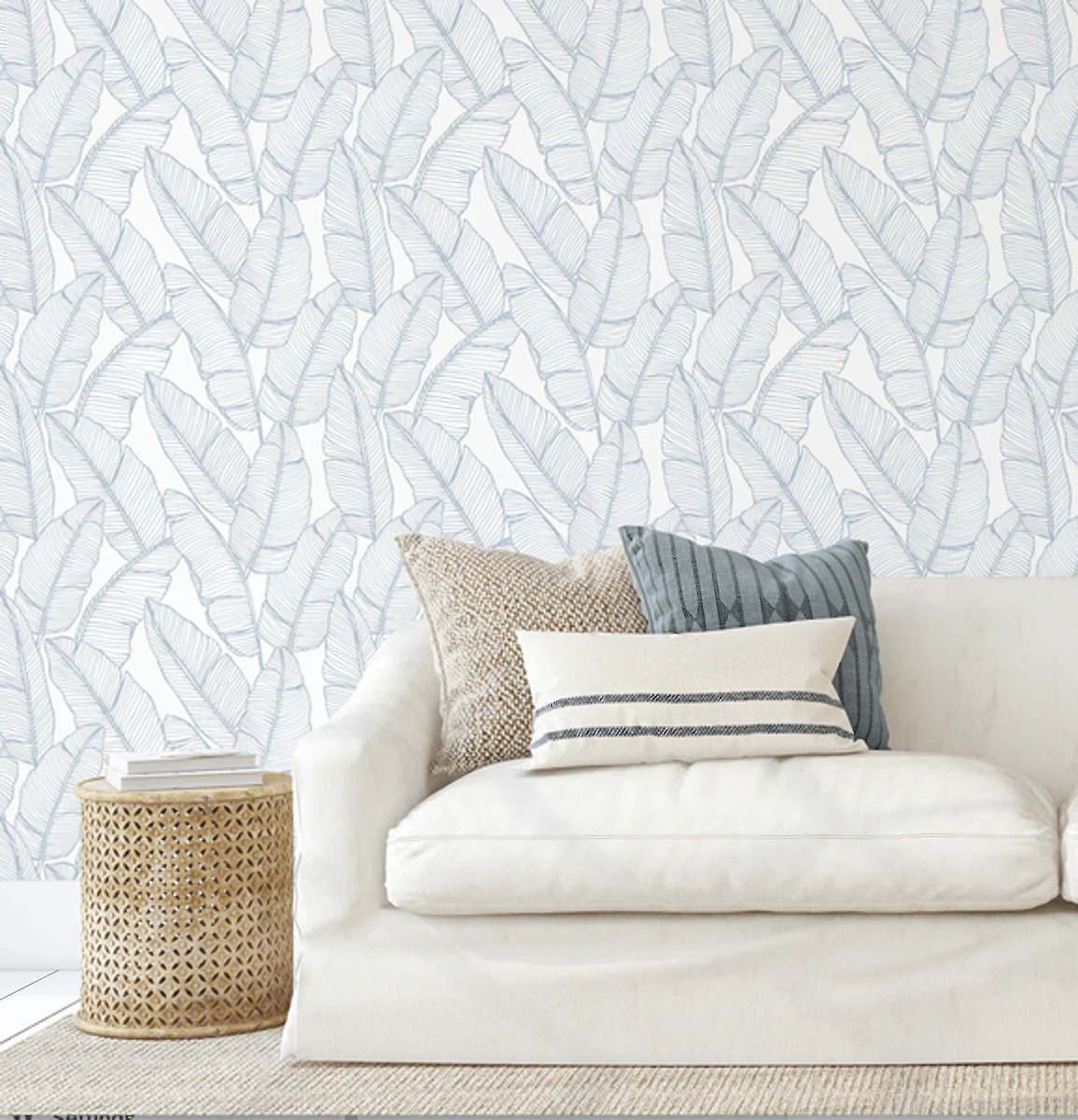Bailey Hamptons Blue Palms wallpaper behind a cream sofa with striped cushions