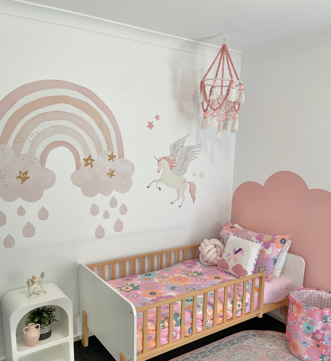 Flying unicorn decal with a rainbow and clouds in a girls bedroom
