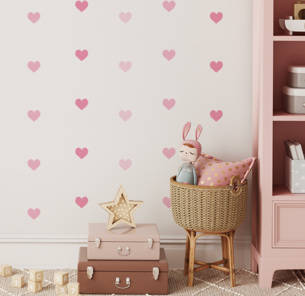 Pink mini heart wall decals beside a cane bassinet and pink shelving