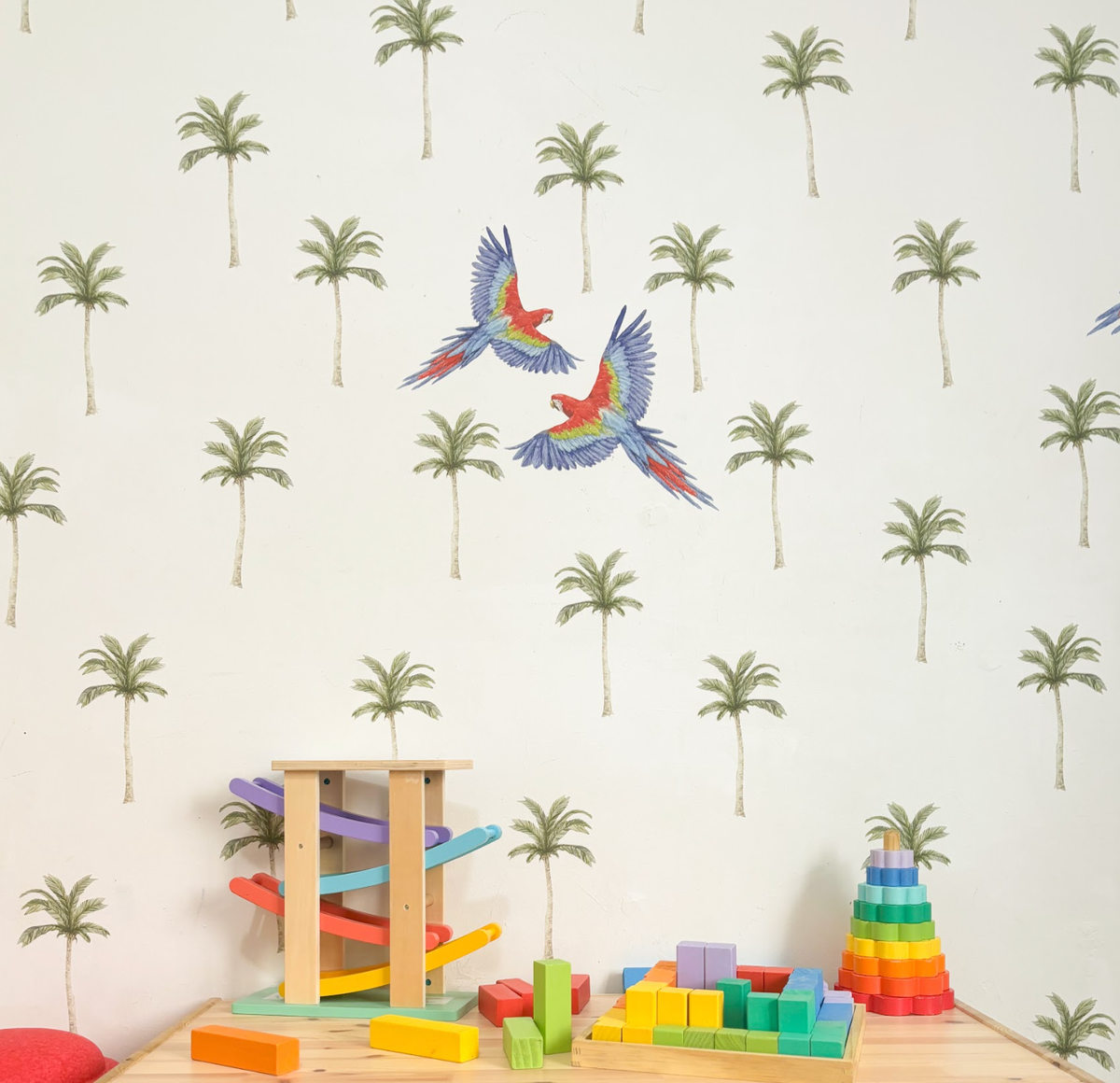 Mini palm tree decals with parrot decals above a toy shelf
