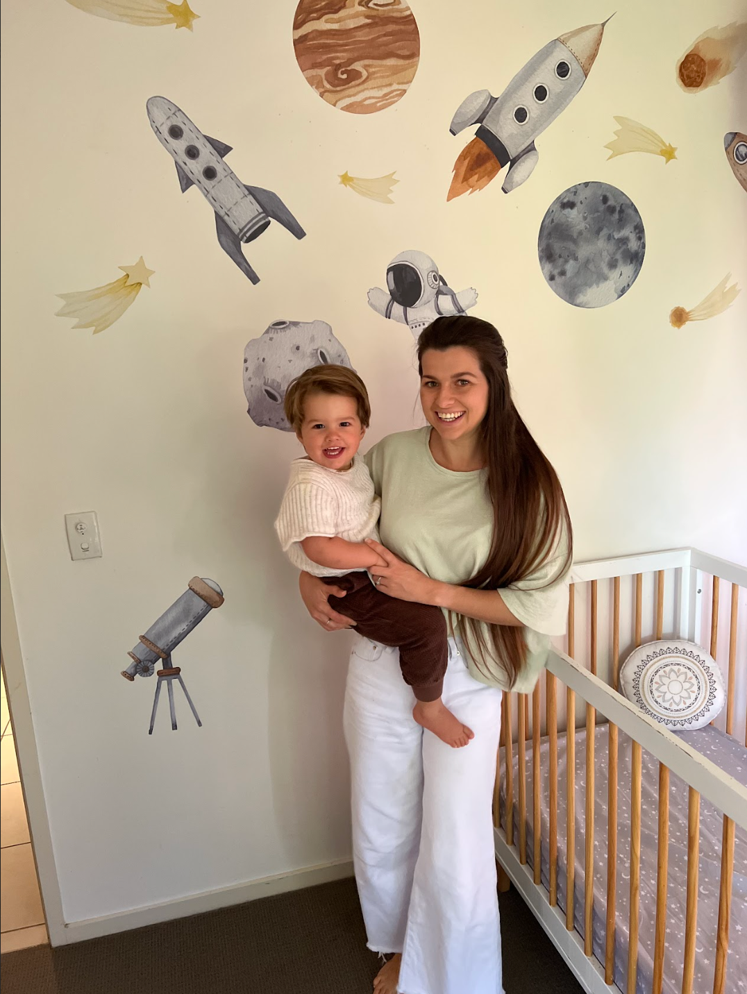Customer photo of a parent and child in front of outer space wall decals