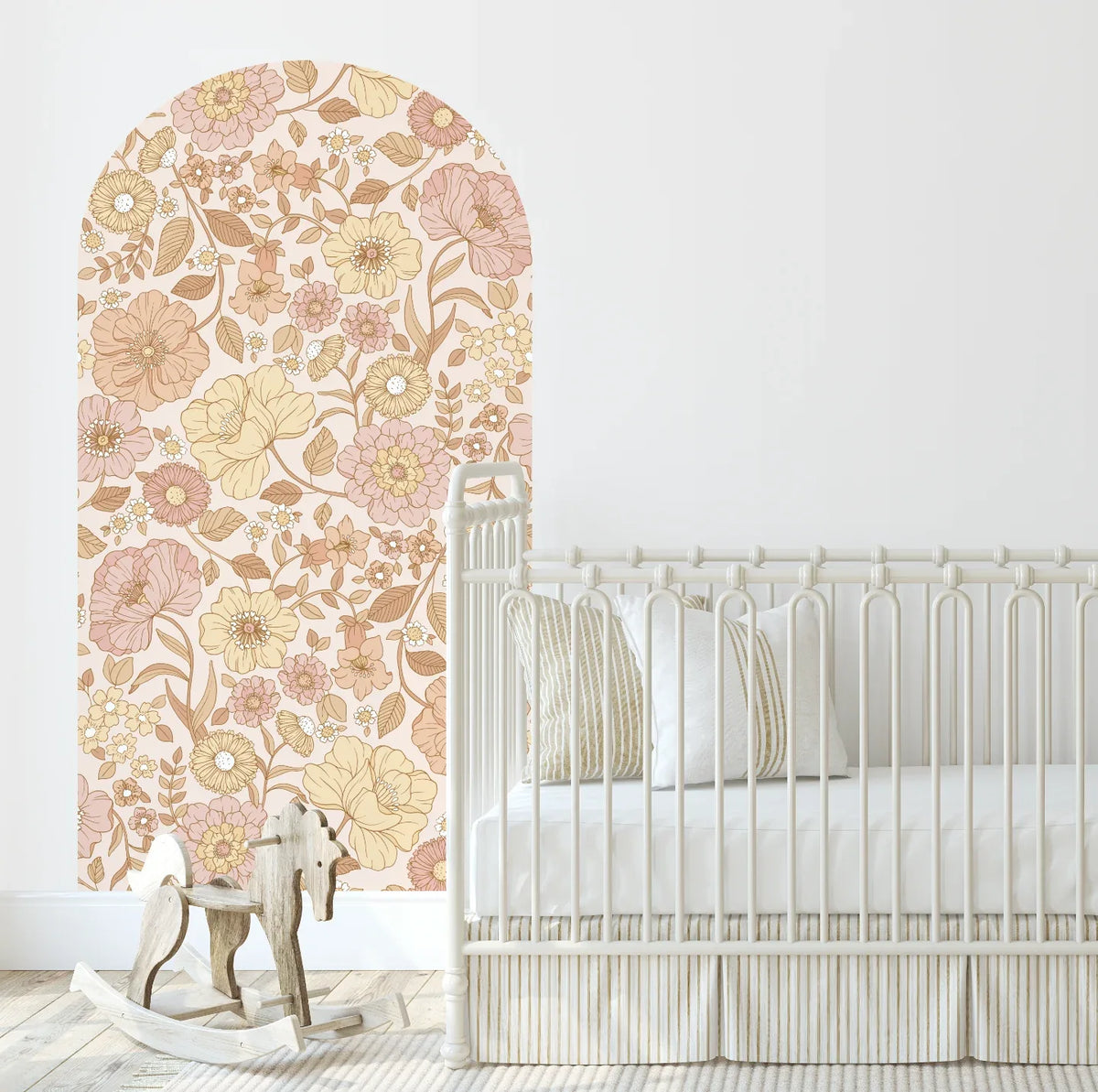 Allie boho floral arch decal in peach behind a white cot