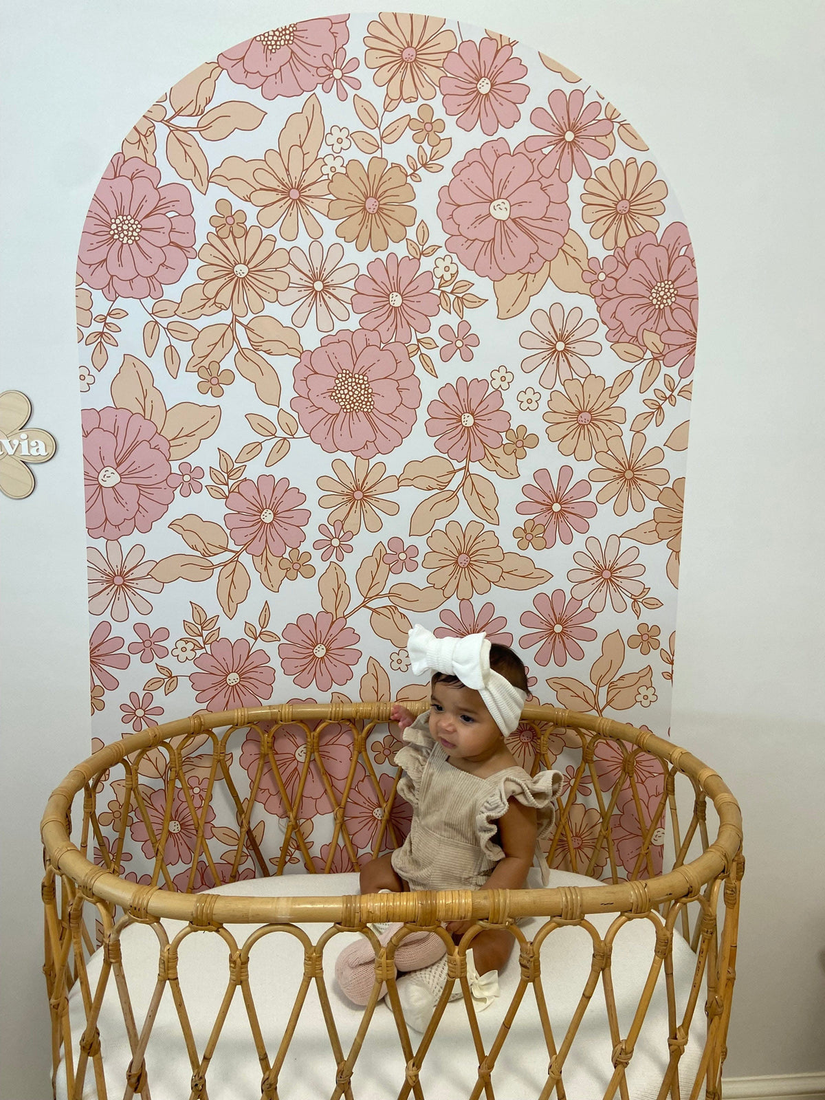 Customer photo of the Skye floral arch decal behind a cane bassinet