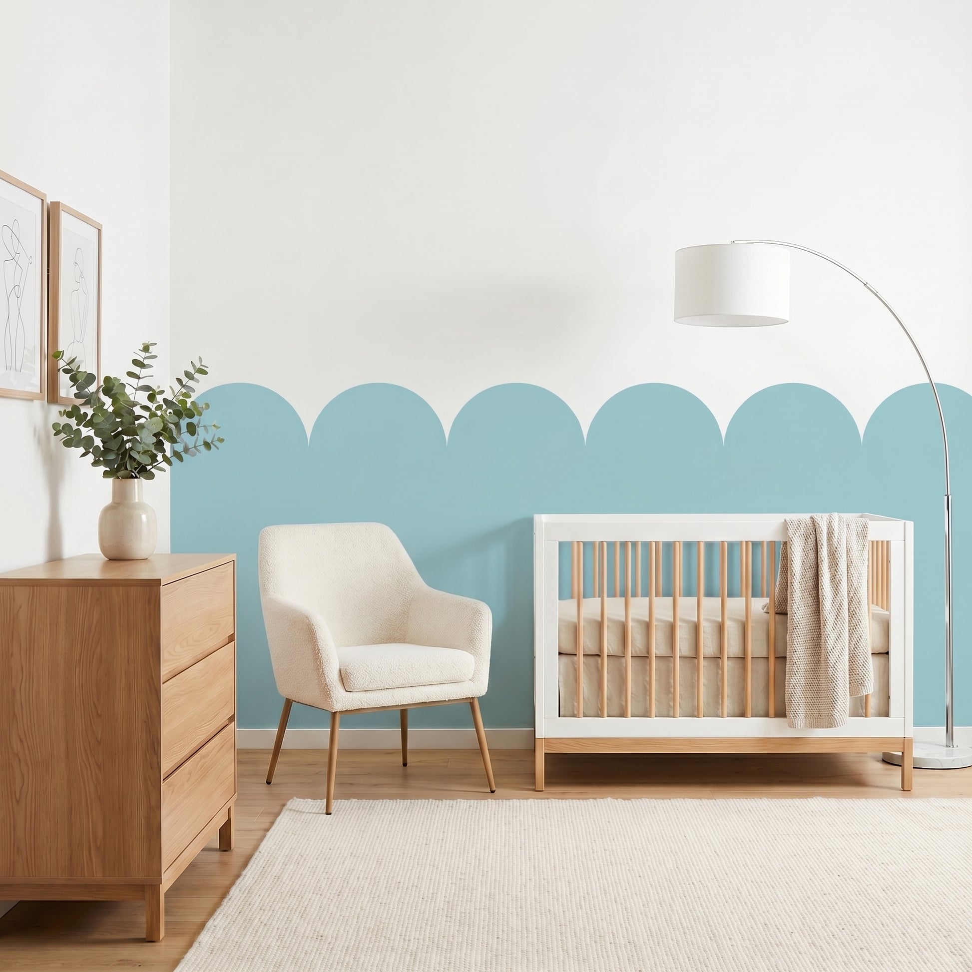 Nursery room with a crib, chair, and dresser against a light blue wall.