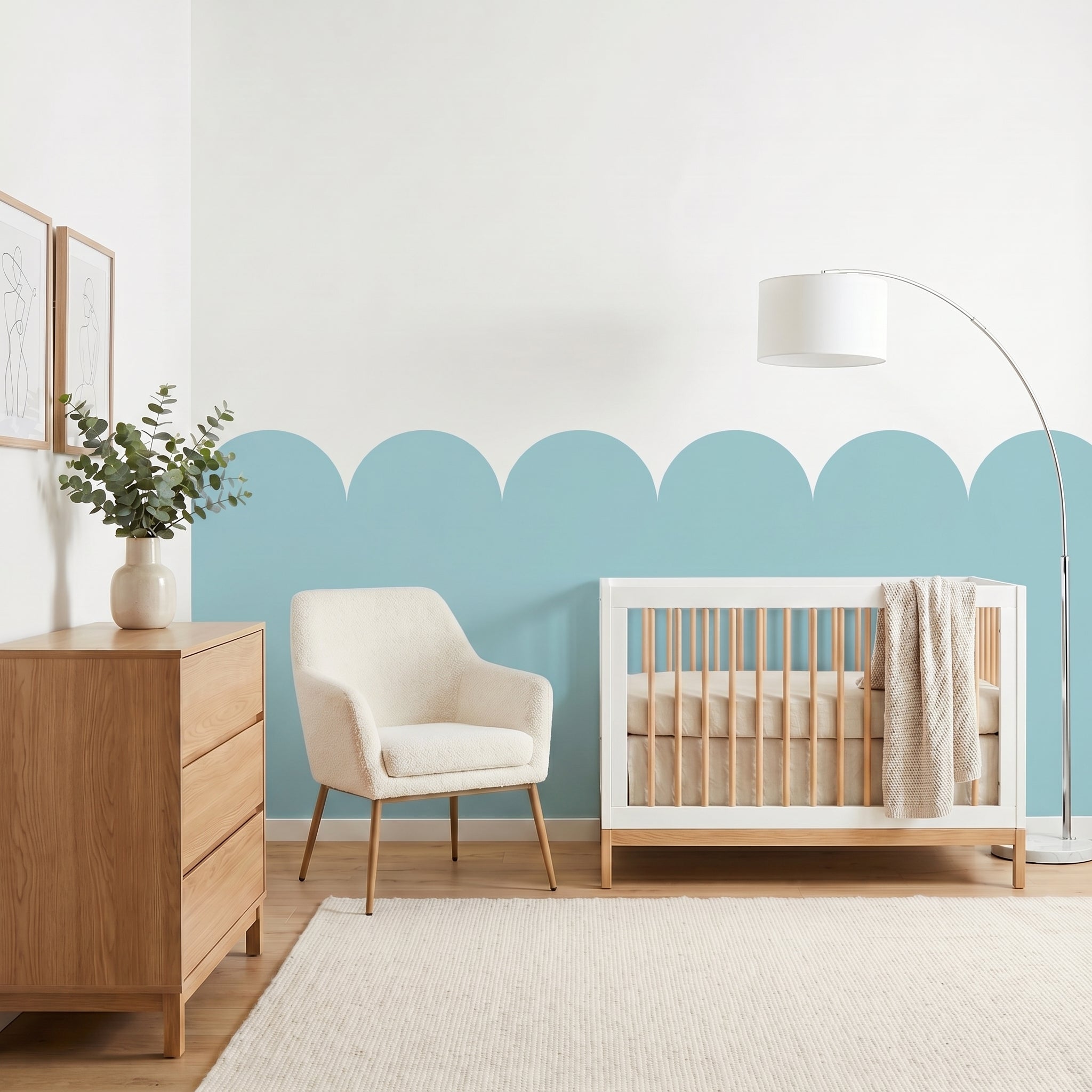 Nursery room with a crib, chair, and dresser against a light blue wall.