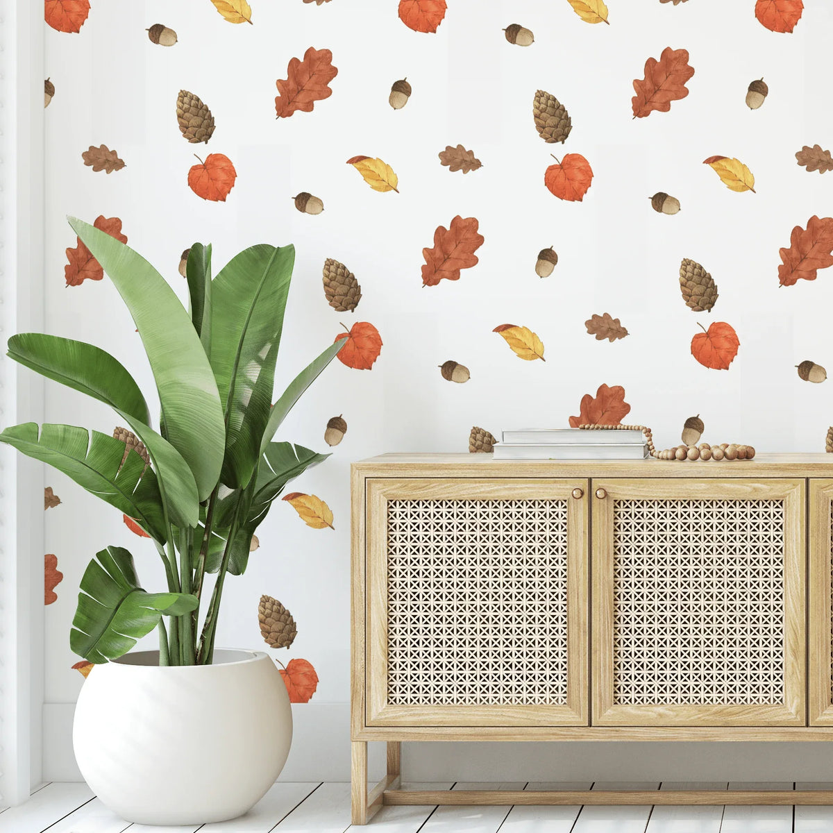 Autumn leaf and pine cone decals scattered above a cane sideboard