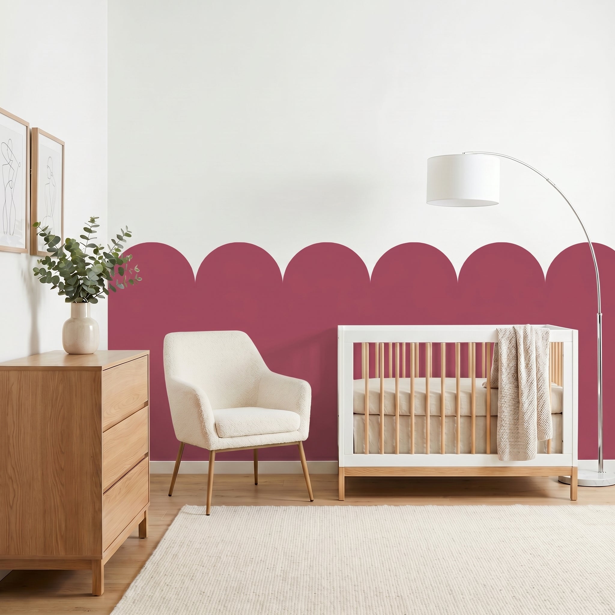 Nursery room with a crib, chair, dresser, and decorative wall.
