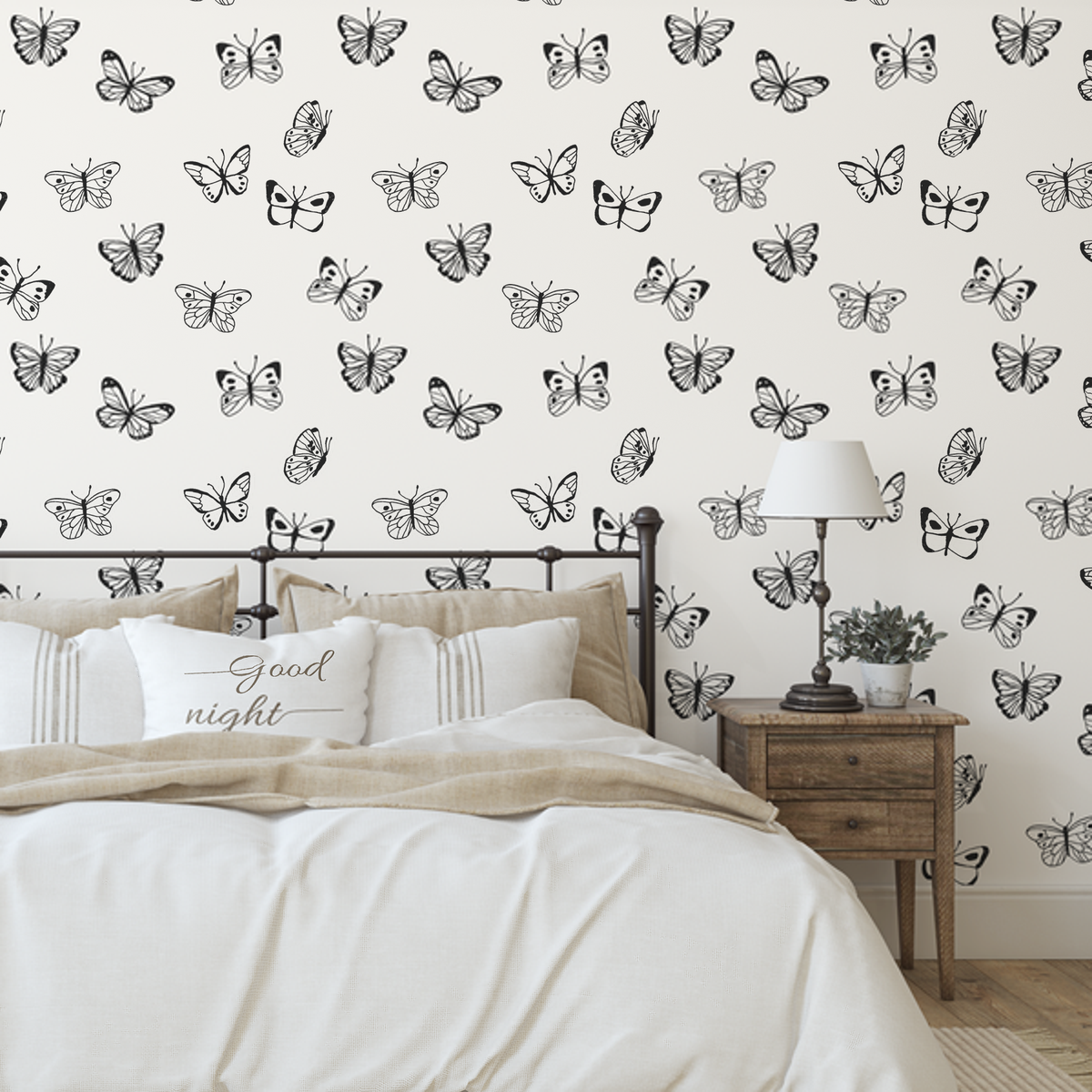 Jane Butterfly wallpaper in a bedroom with an iron bed and timber bedside table
