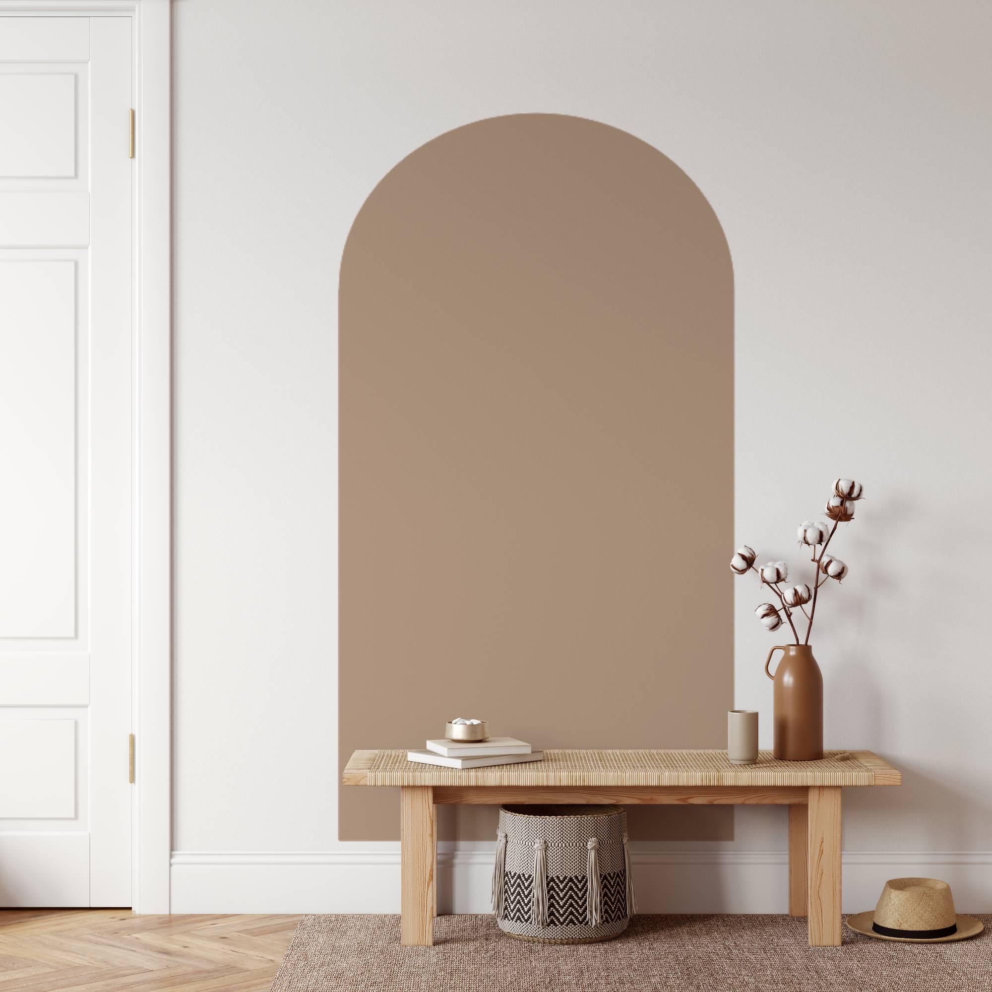 Beige wall mirror above a wooden bench with decorative items in a minimalistic room.