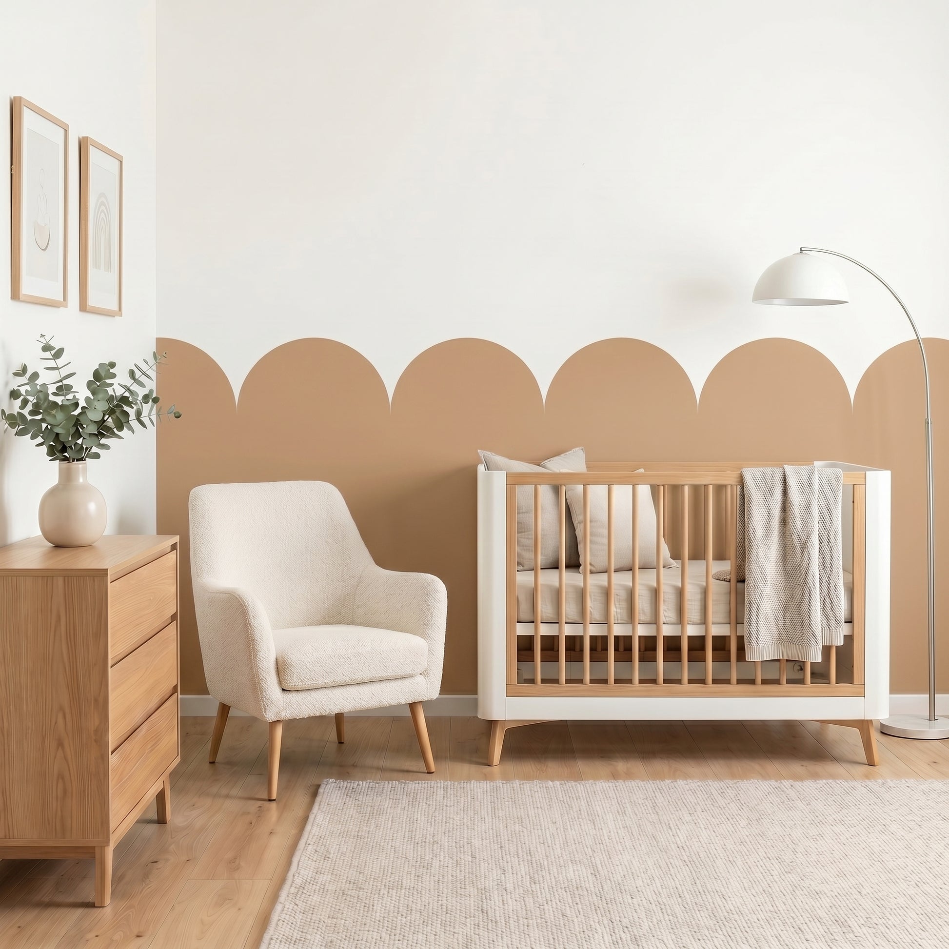 Nursery room with wooden crib, white armchair, and dresser against a beige wall.