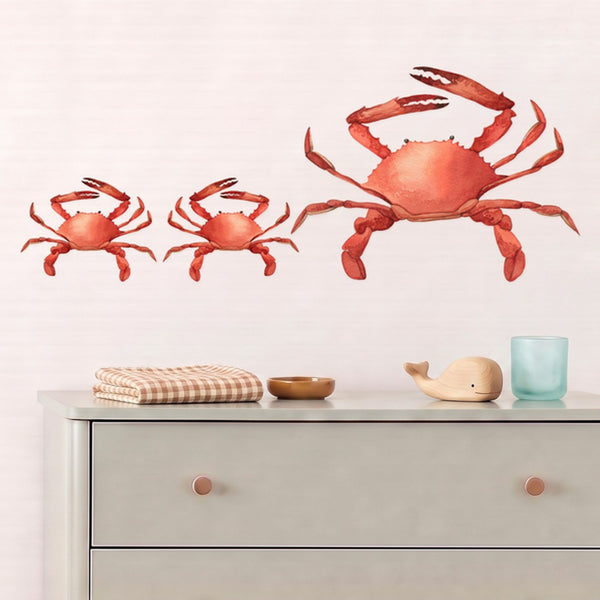 Large crab family wall decals, a crab and two baby crabs, above a sage chest of drawers in a nursery