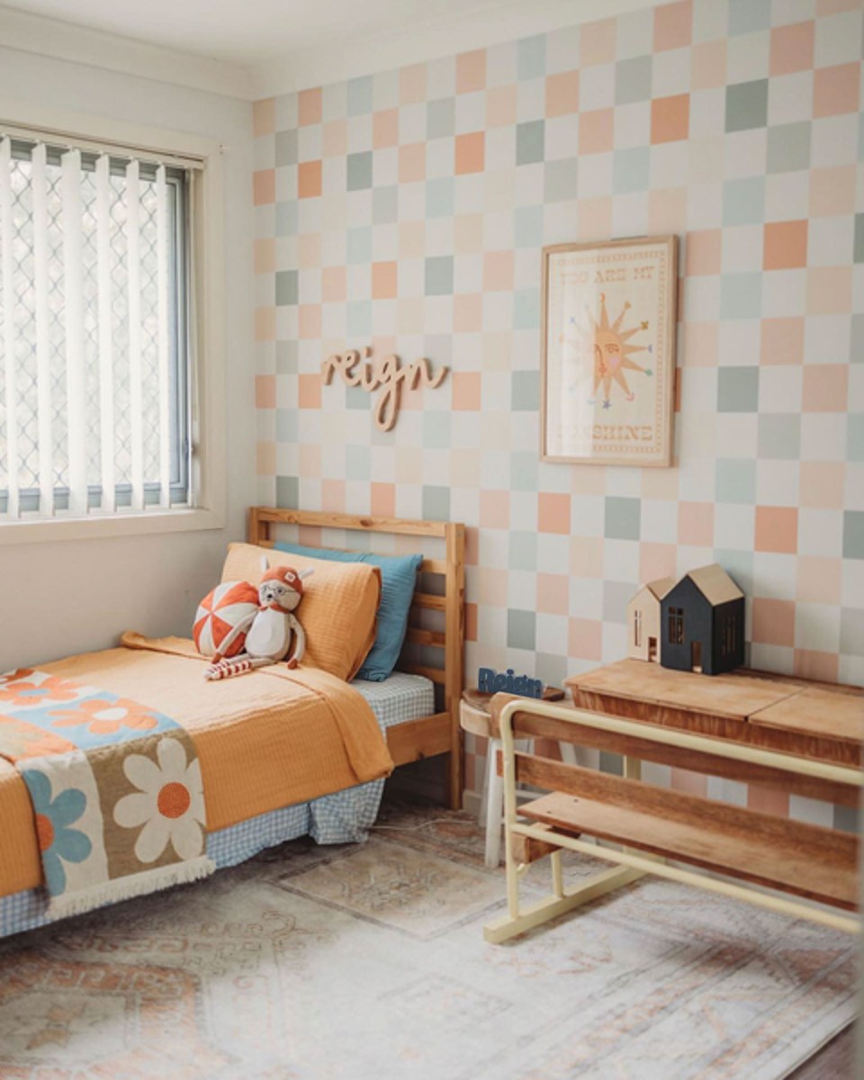 Colourful Checker wallpaper in a kids bedroom with a timber bed and orange bedding