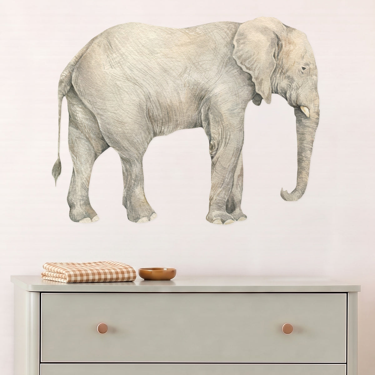 Large elephant wall decal above a sage chest of drawers in a nursery