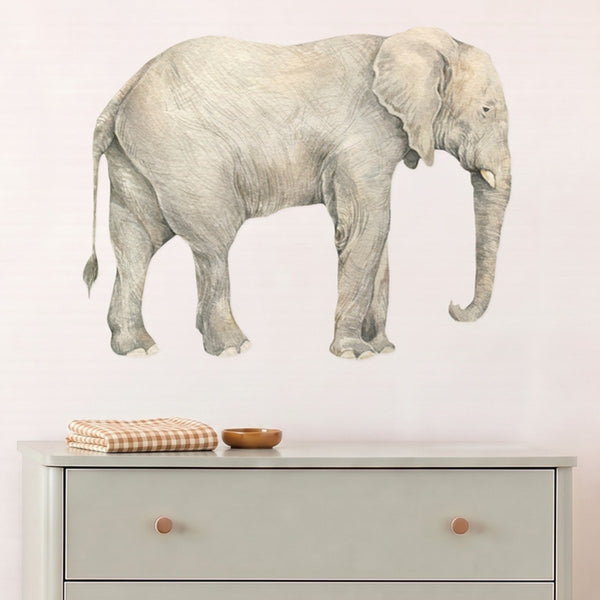 Large elephant wall decal above a sage chest of drawers in a nursery