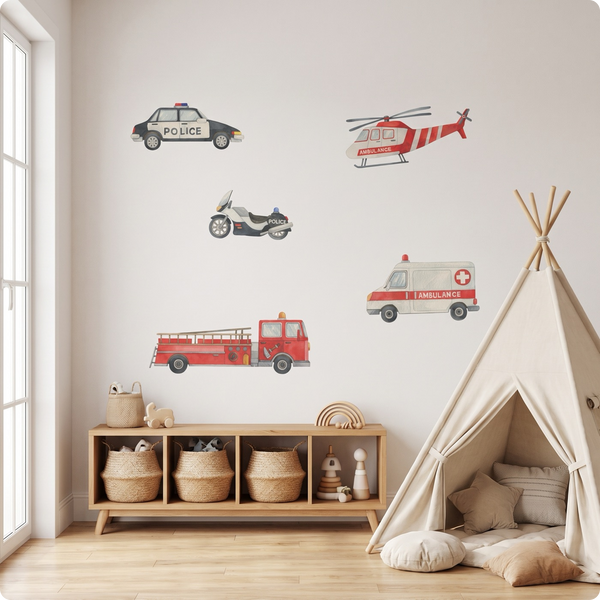 A children's playroom scene with wall decals of a police car, ambulance, helicopter, motorcycle, and fire truck displayed above a low wooden cabinet, next to a teepee tent.