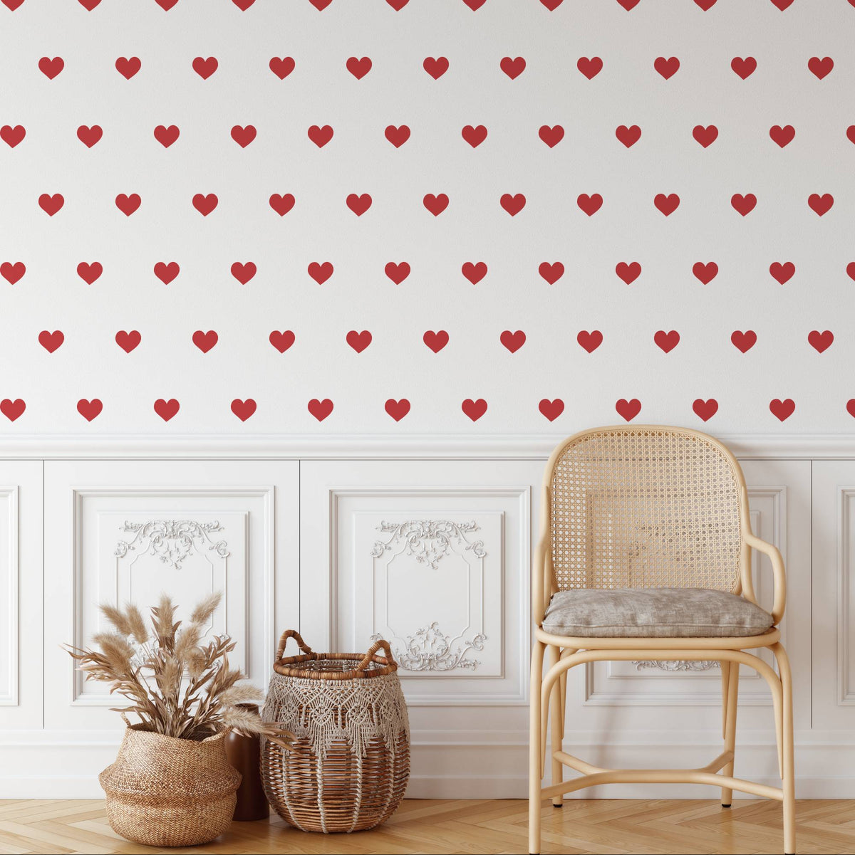 Red mini heart wall decals scattered above wall panelling with a rattan chair