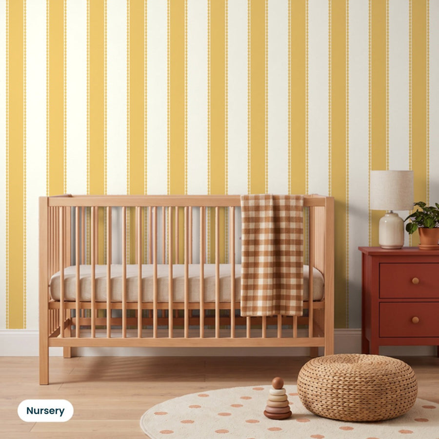 Henrietta Butterscotch Stripes wallpaper in a nursery with an oak cot and rust bedside chest