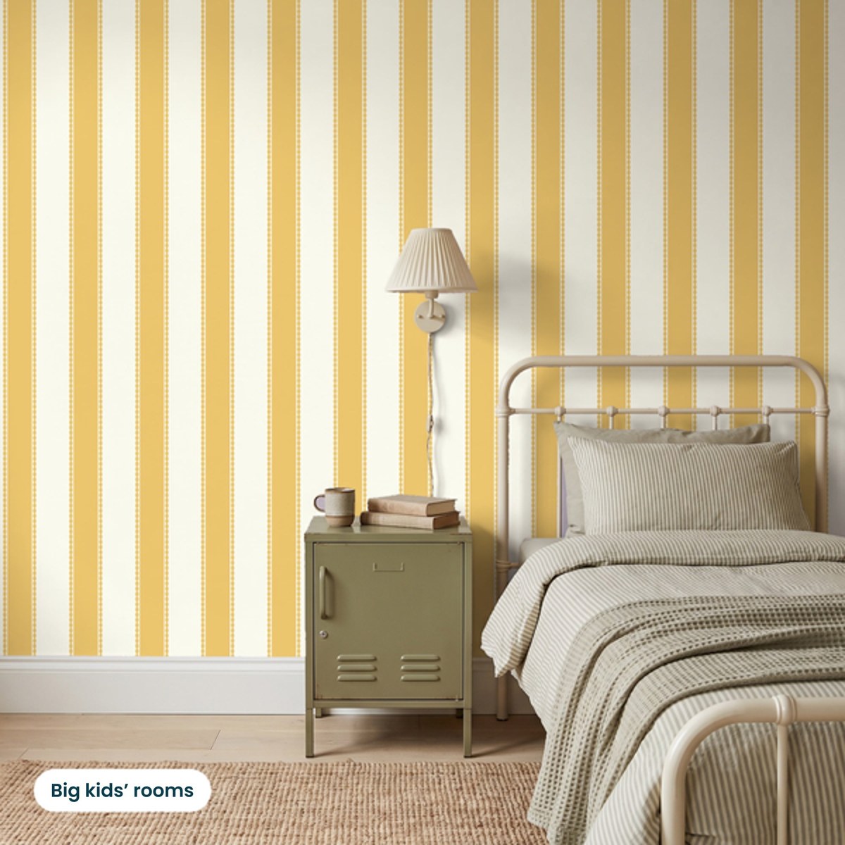 Henrietta Butterscotch Stripes wallpaper in a big kid's bedroom with a cream metal bed and olive locker