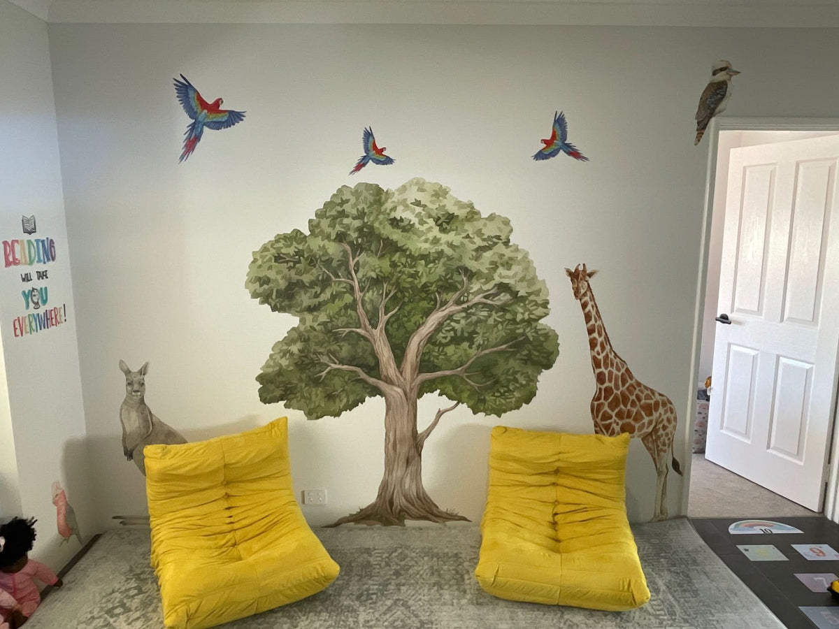 Customer photo of an oak tree decal with birds and a giraffe in a playroom