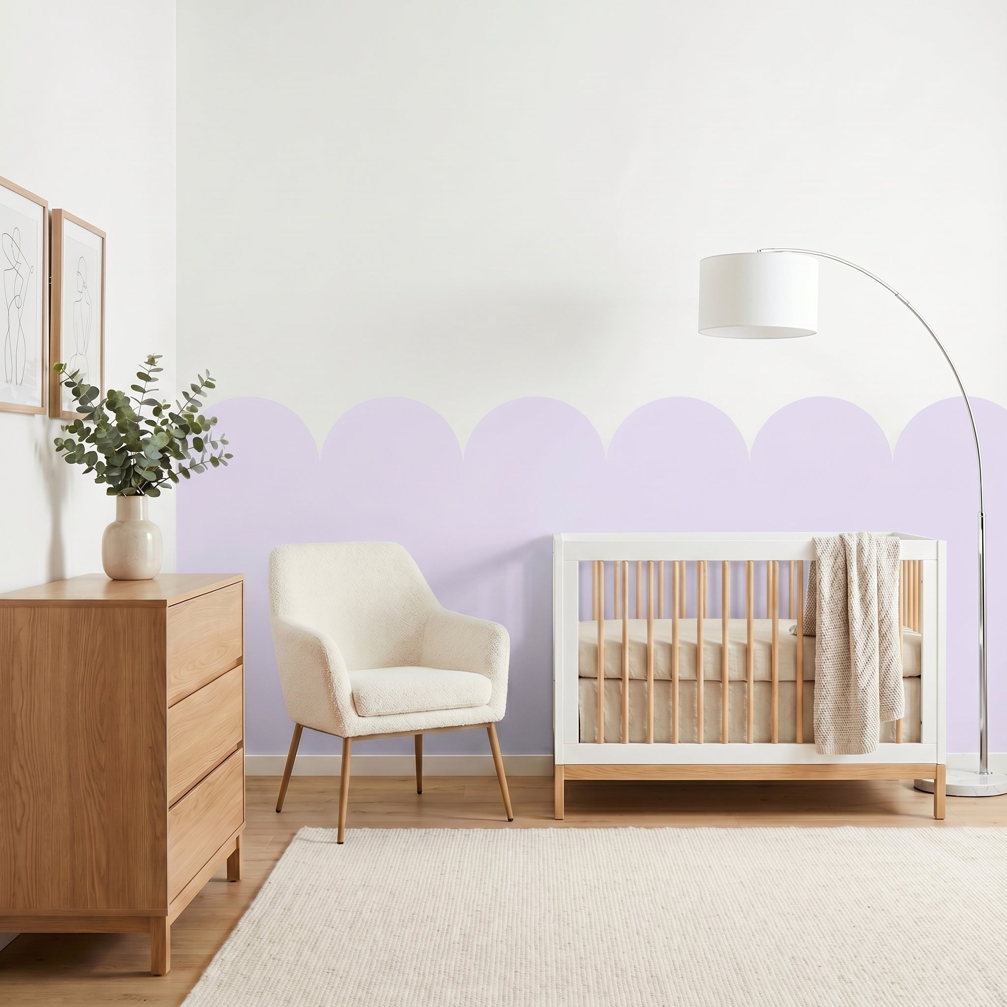 Nursery room with wooden crib, chair, and dresser against a light purple wall.