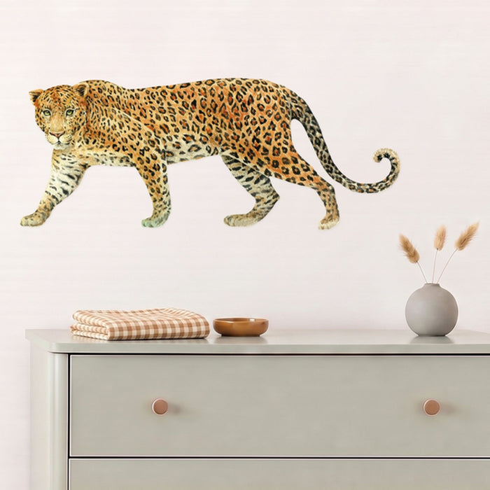 Leopard wall decal above a sage chest of drawers in a nursery