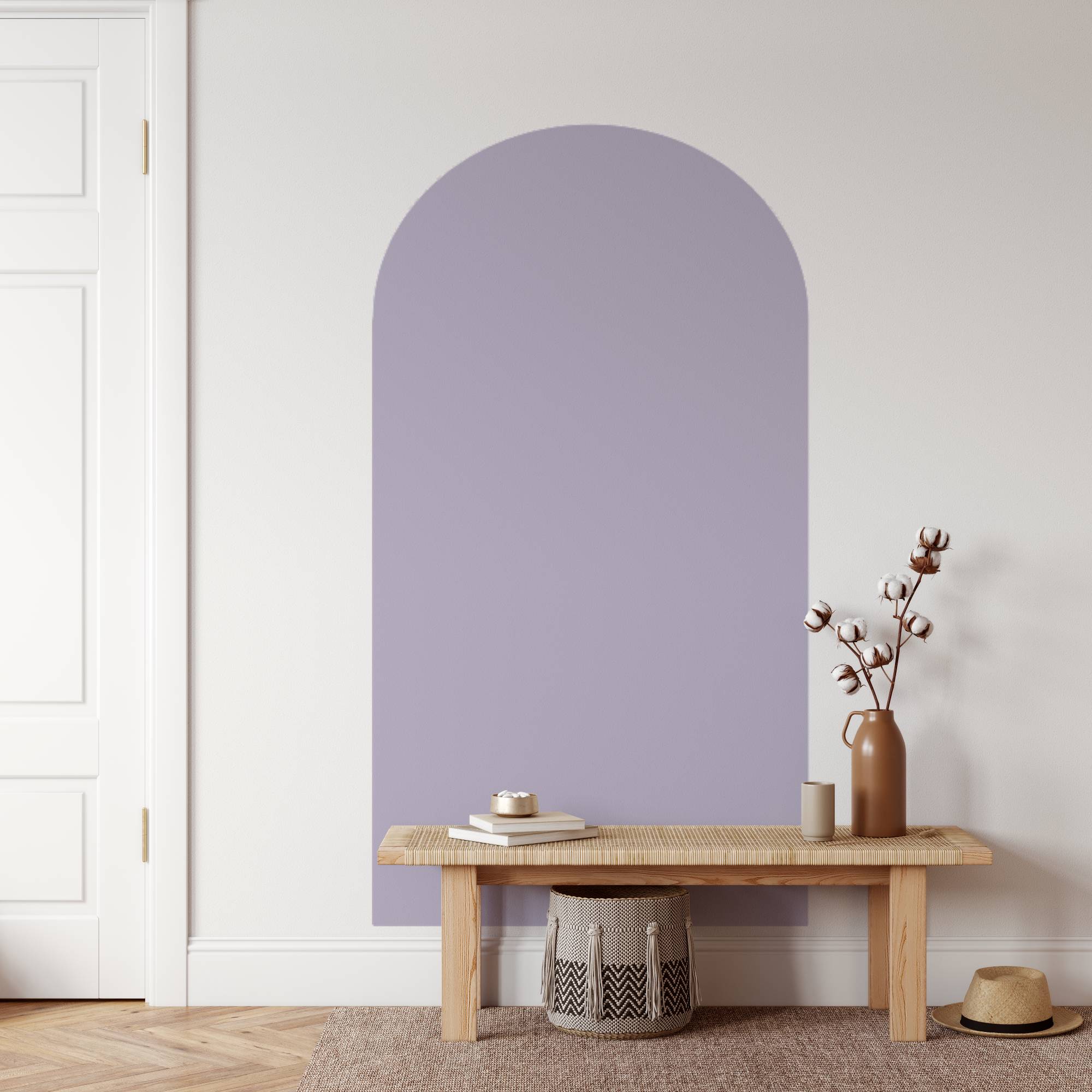Wooden bench with a vase and books against a light purple wall.