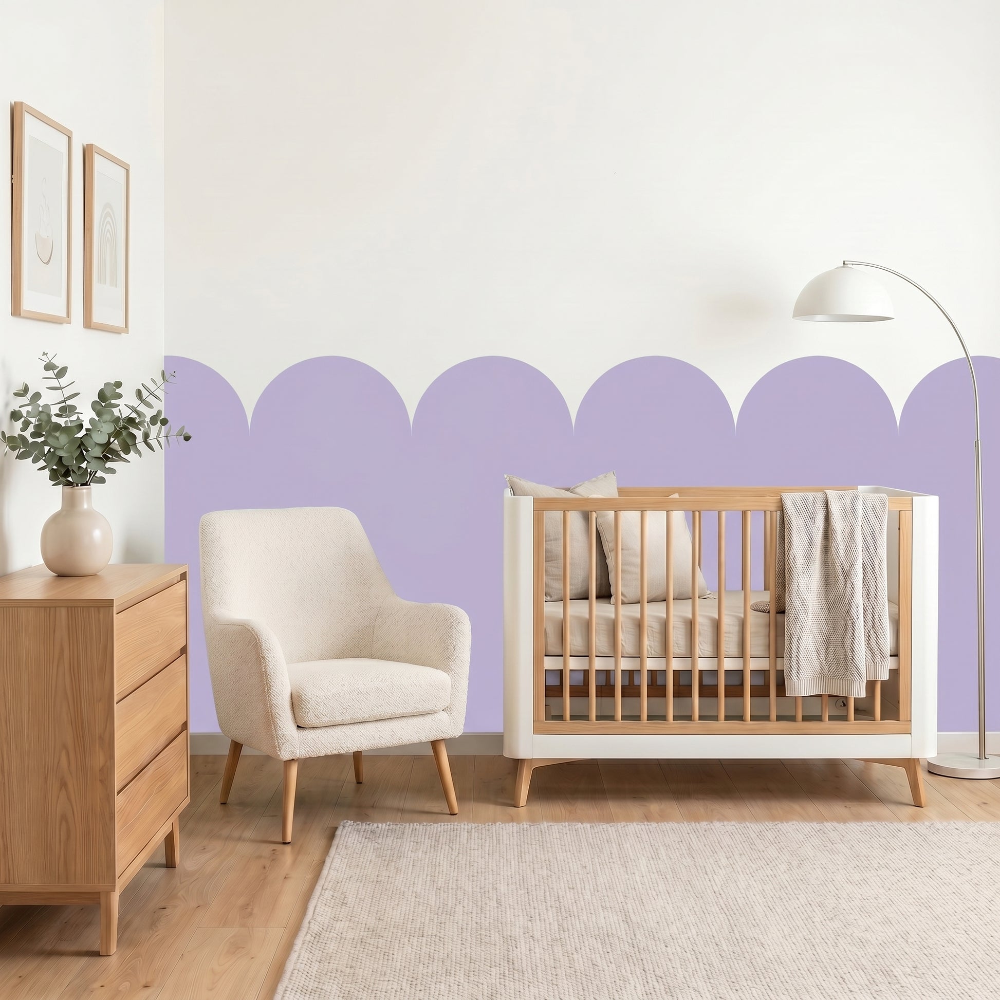 Nursery room with wooden crib, armchair, and dresser against a purple wall.