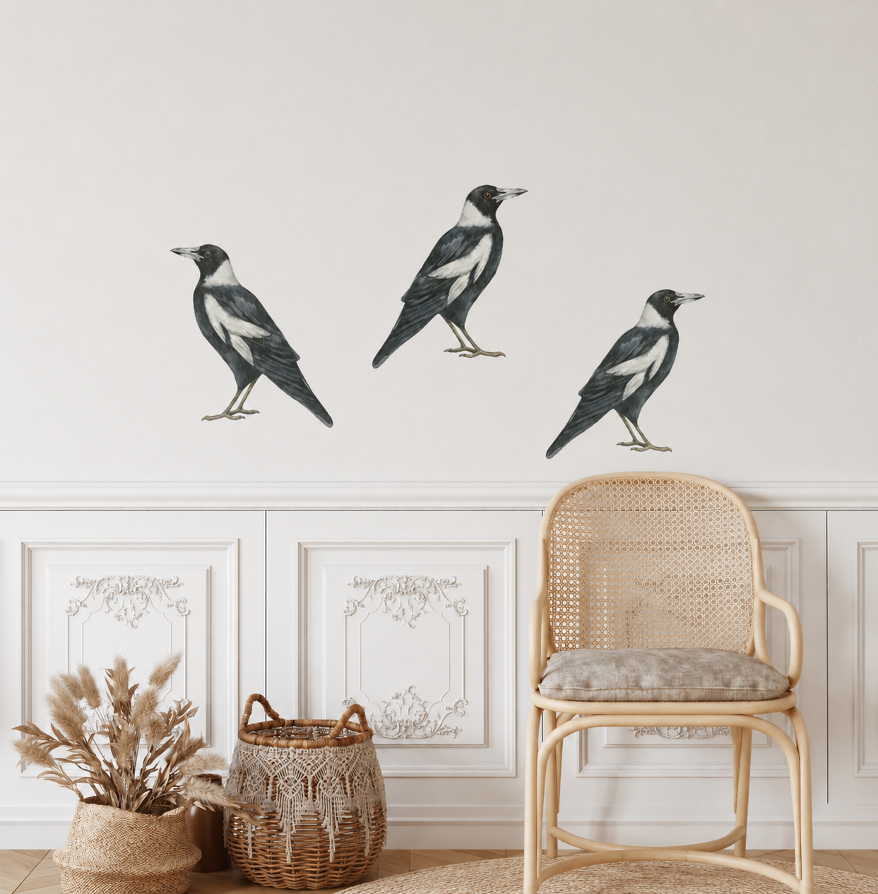 Three magpie wall decals on a light-colored wall with a chair and decorative items below.