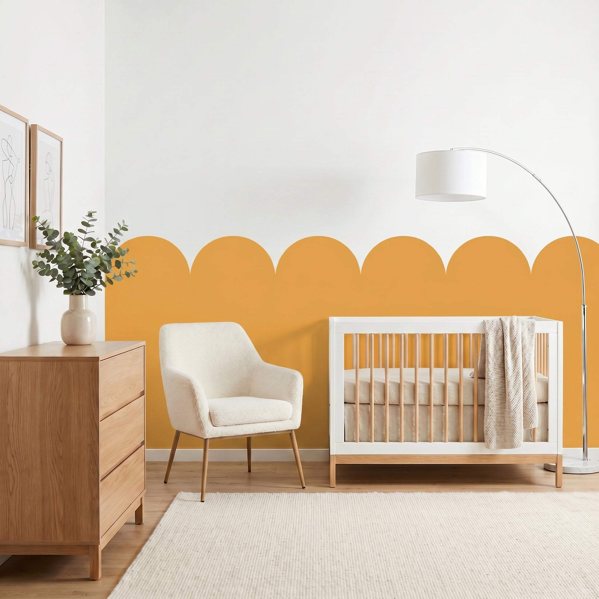 Nursery room with a white crib, wooden dresser, and armchair against a yellow accent wall.