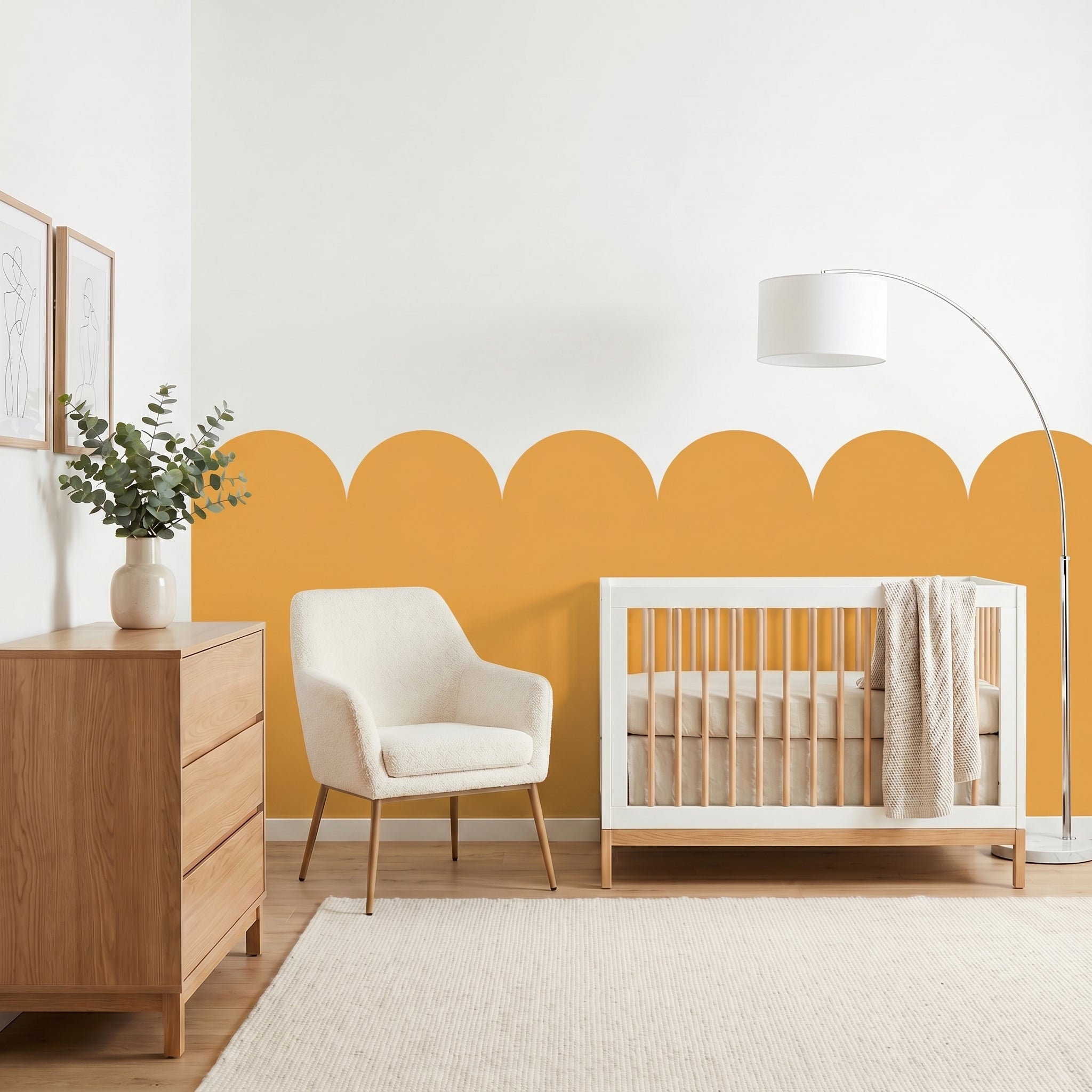 Nursery room with a white crib, wooden dresser, and armchair against a yellow accent wall.