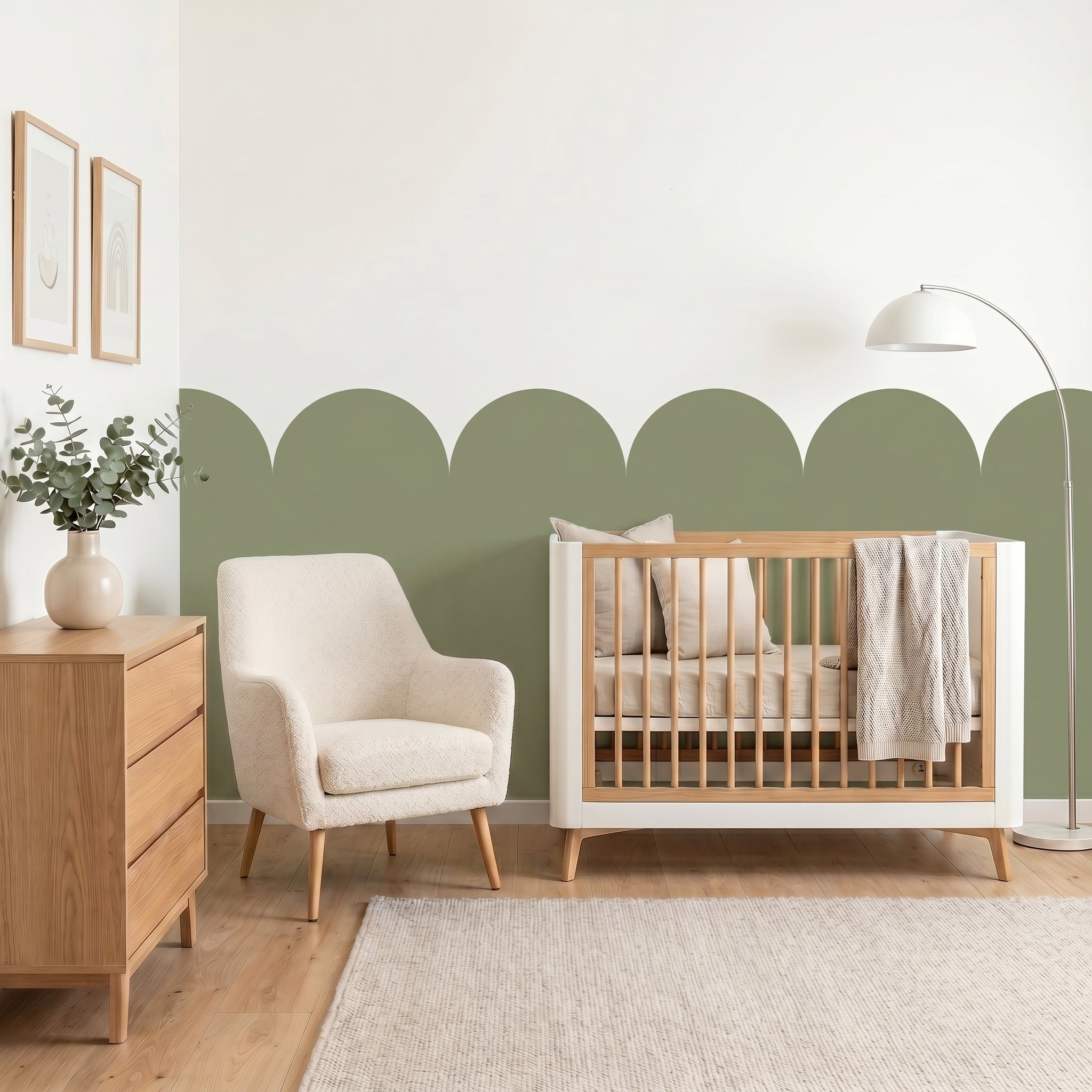 Nursery room with wooden crib, armchair, and dresser against a green and white wall.