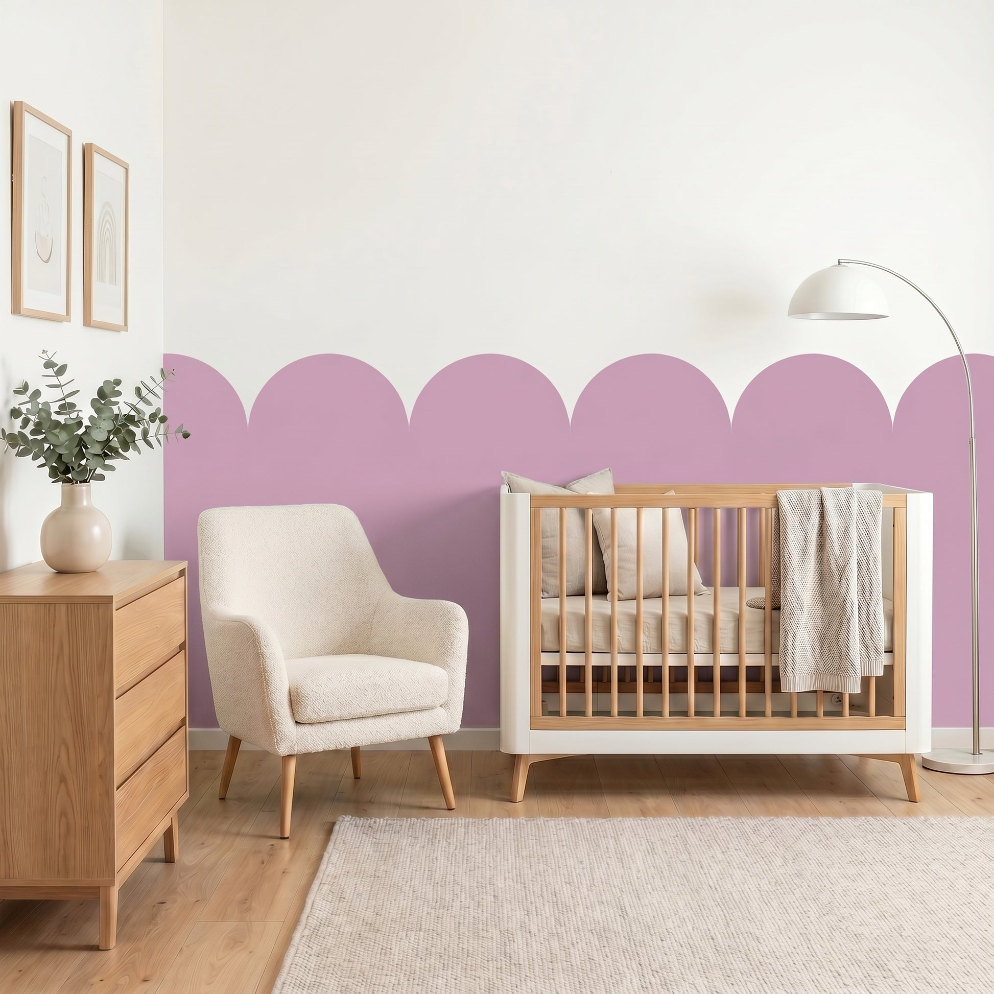 Nursery room with wooden crib, white armchair, and decorative purple wall.