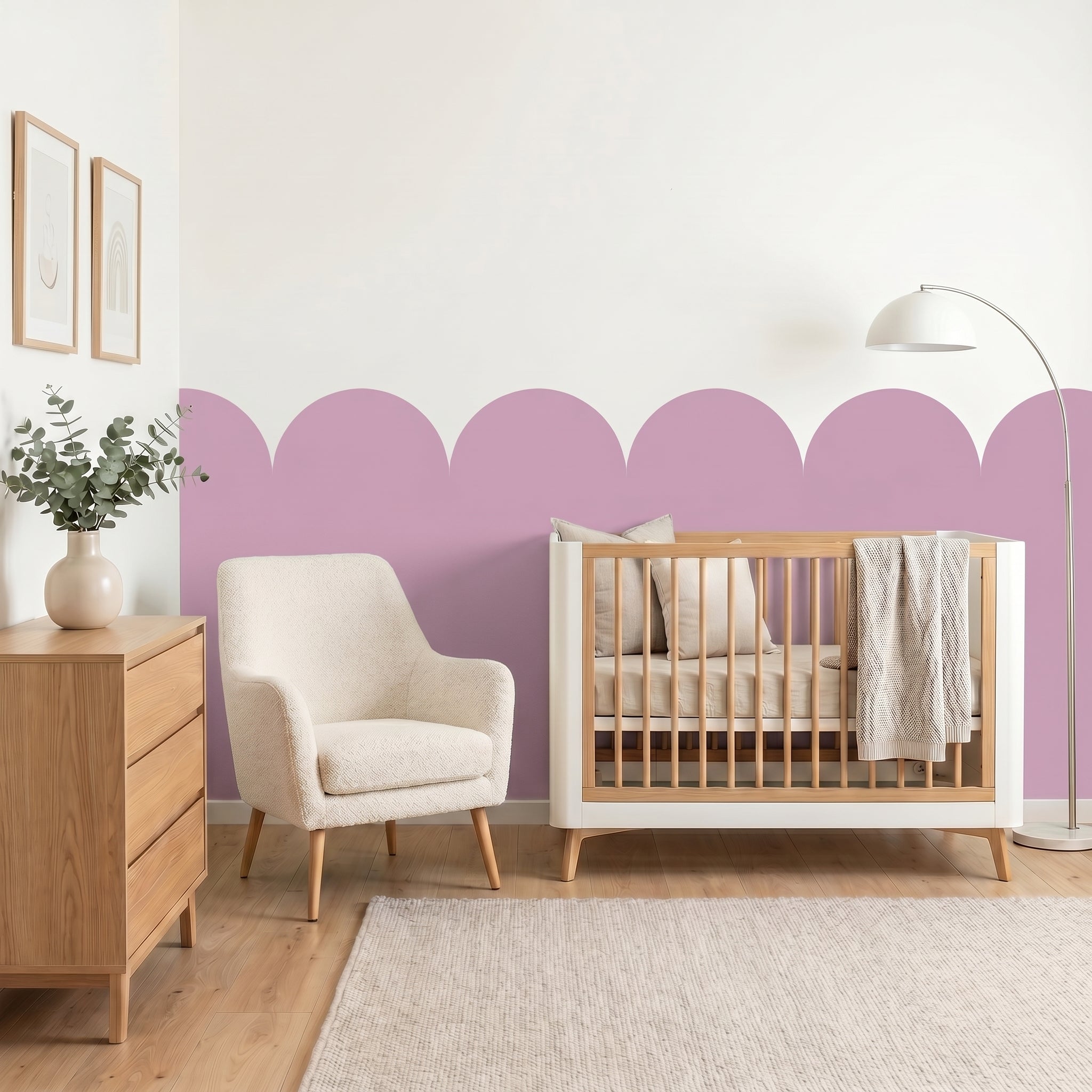 Nursery room with wooden crib, white armchair, and decorative purple wall.
