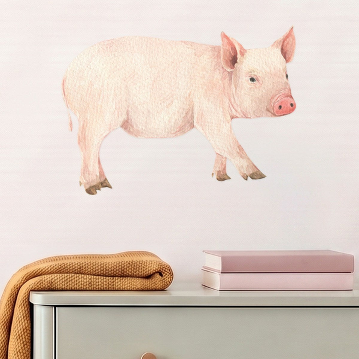 Large pig wall decal above a sage dresser in a nursery