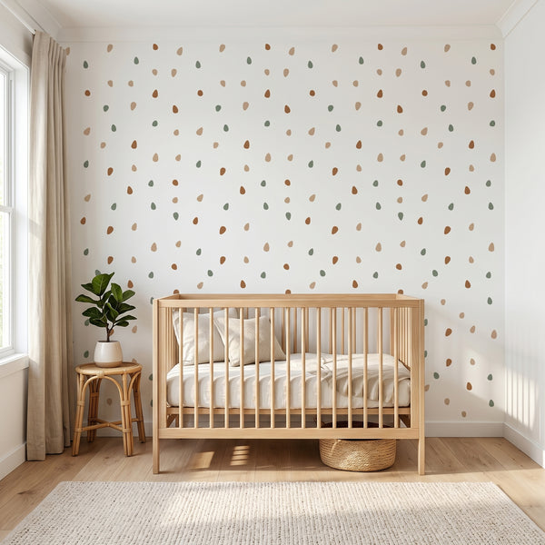 Nursery room with wooden crib, polka dot wall paper, and plant decor.