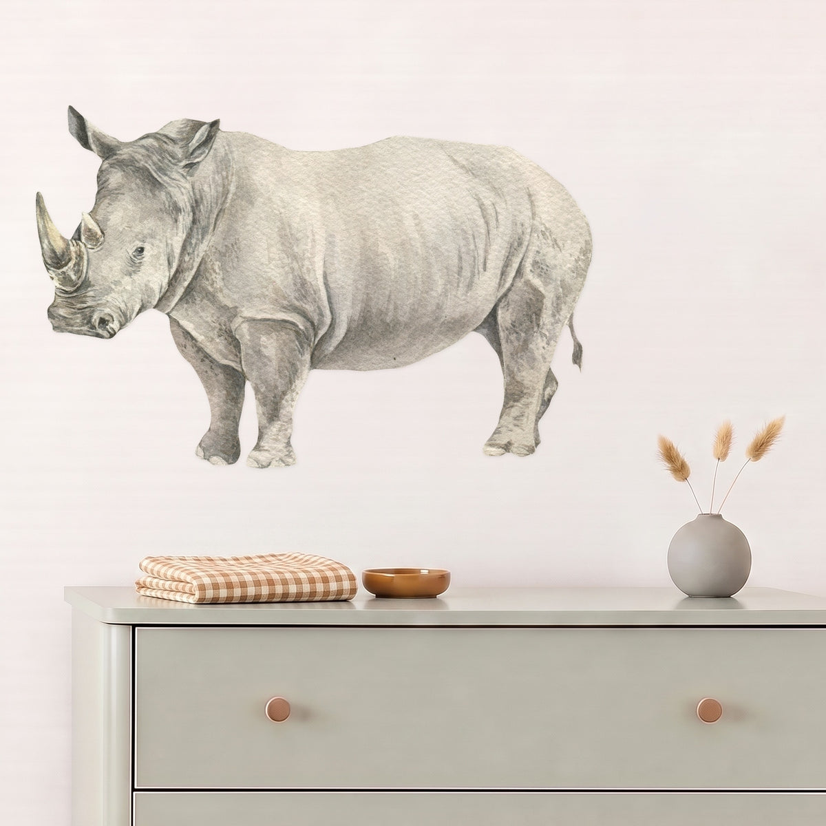 Rhino wall decal above a sage dresser in a styled nursery