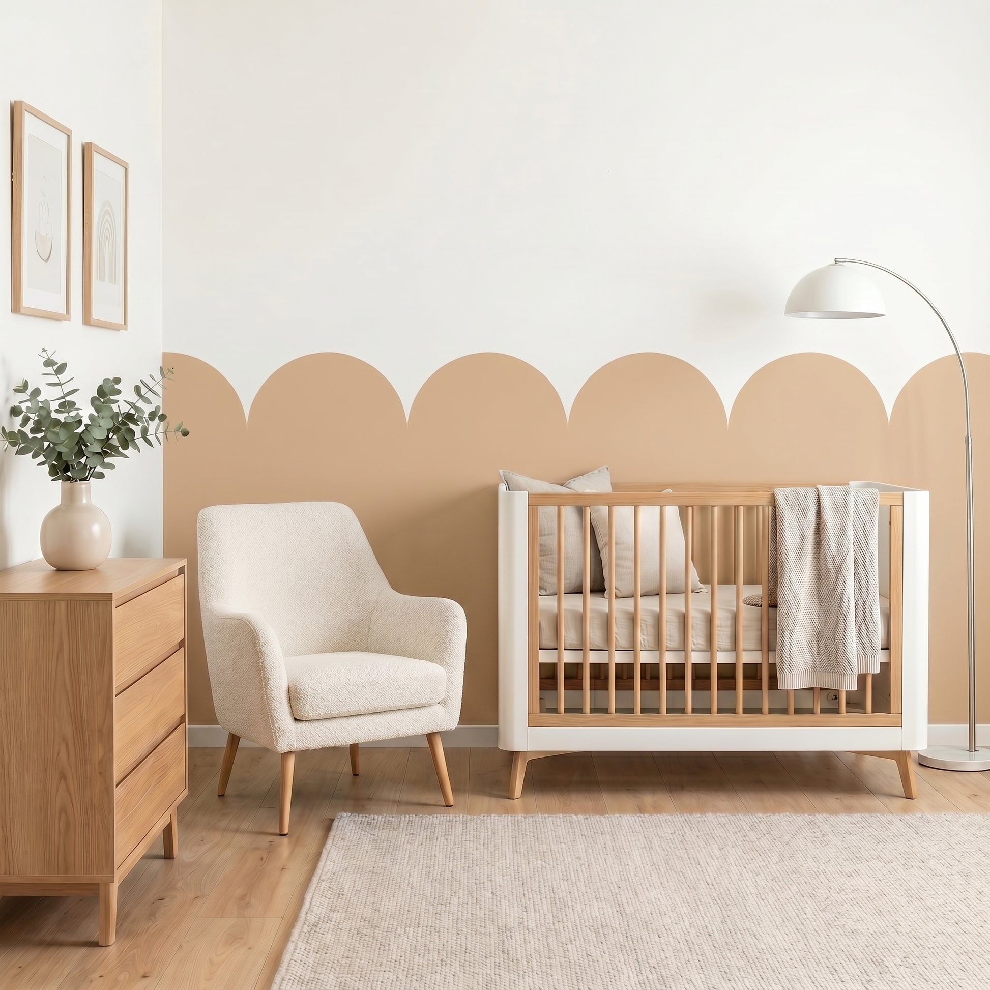 Nursery room with wooden crib, white armchair, and dresser against a beige wall.
