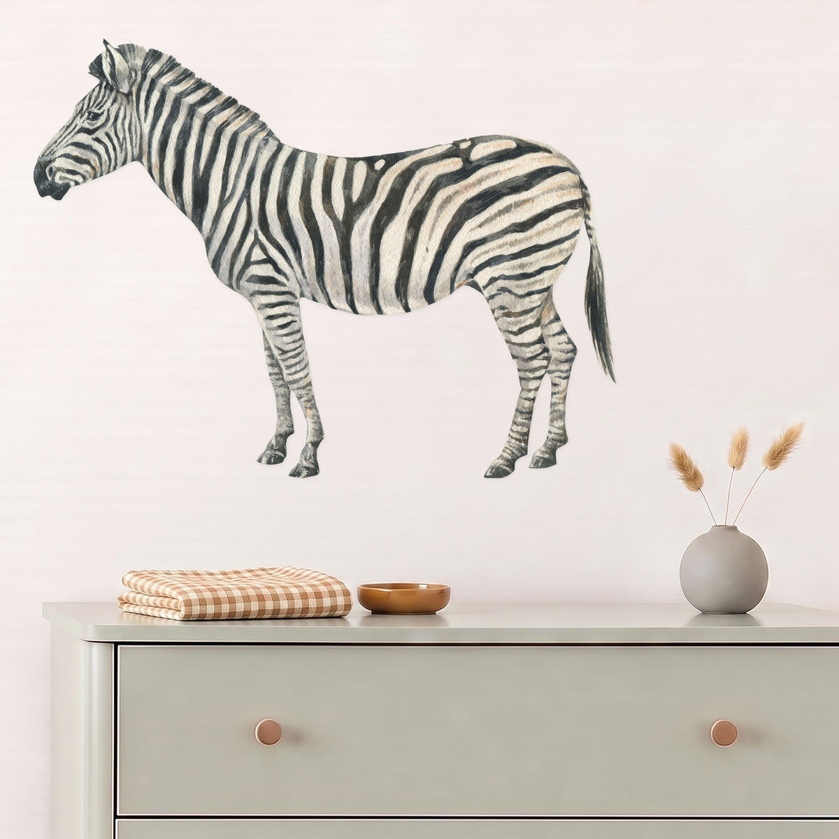 Large zebra wall decal above a sage dresser in a nursery