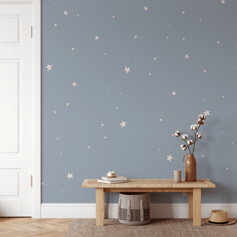 Aries Denim Blue Star wallpaper behind a timber bench and woven basket