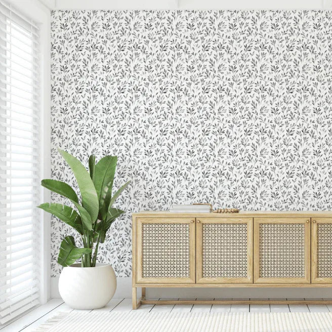Room interior with a wooden sideboard, potted plant, and floral wallpaper.